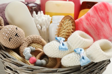 Photo of Wicker basket with baby cosmetics and accessories, closeup view
