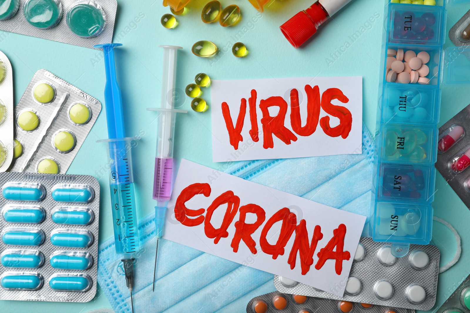 Photo of Flat lay composition with phrase CORONA VIRUS and medicines on light blue background