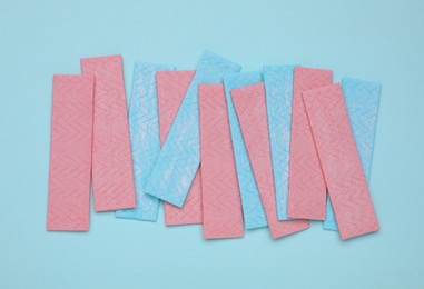 Many sticks of tasty chewing gum on turquoise background, flat lay