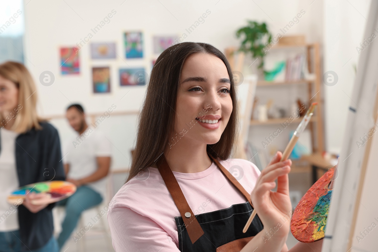 Photo of Group of students attending painting class in studio. Creative hobby