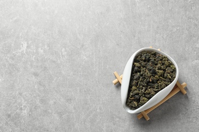 Photo of Chahe of Tie Guan Yin oolong tea leaves on grey background, top view with space for text