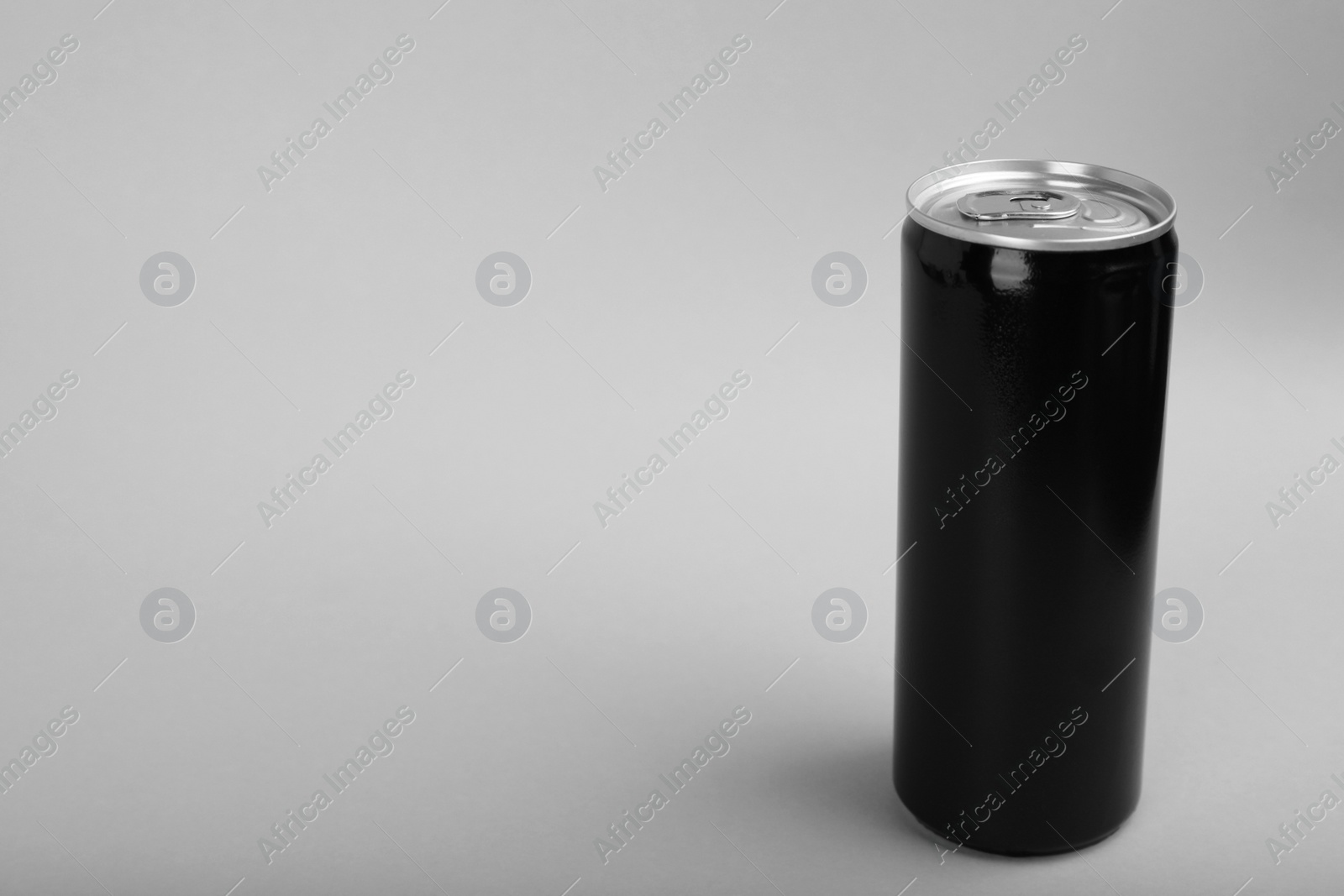 Photo of Black can of energy drink on light grey background. Space for text