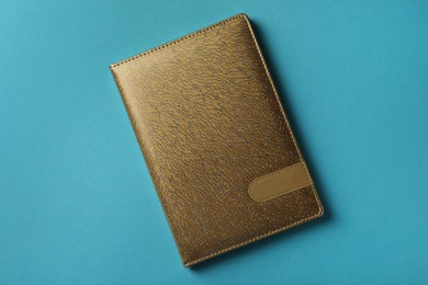 Photo of New stylish planner with leather cover on light blue background, top view