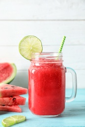 Photo of Tasty summer watermelon drink in mason jar on table