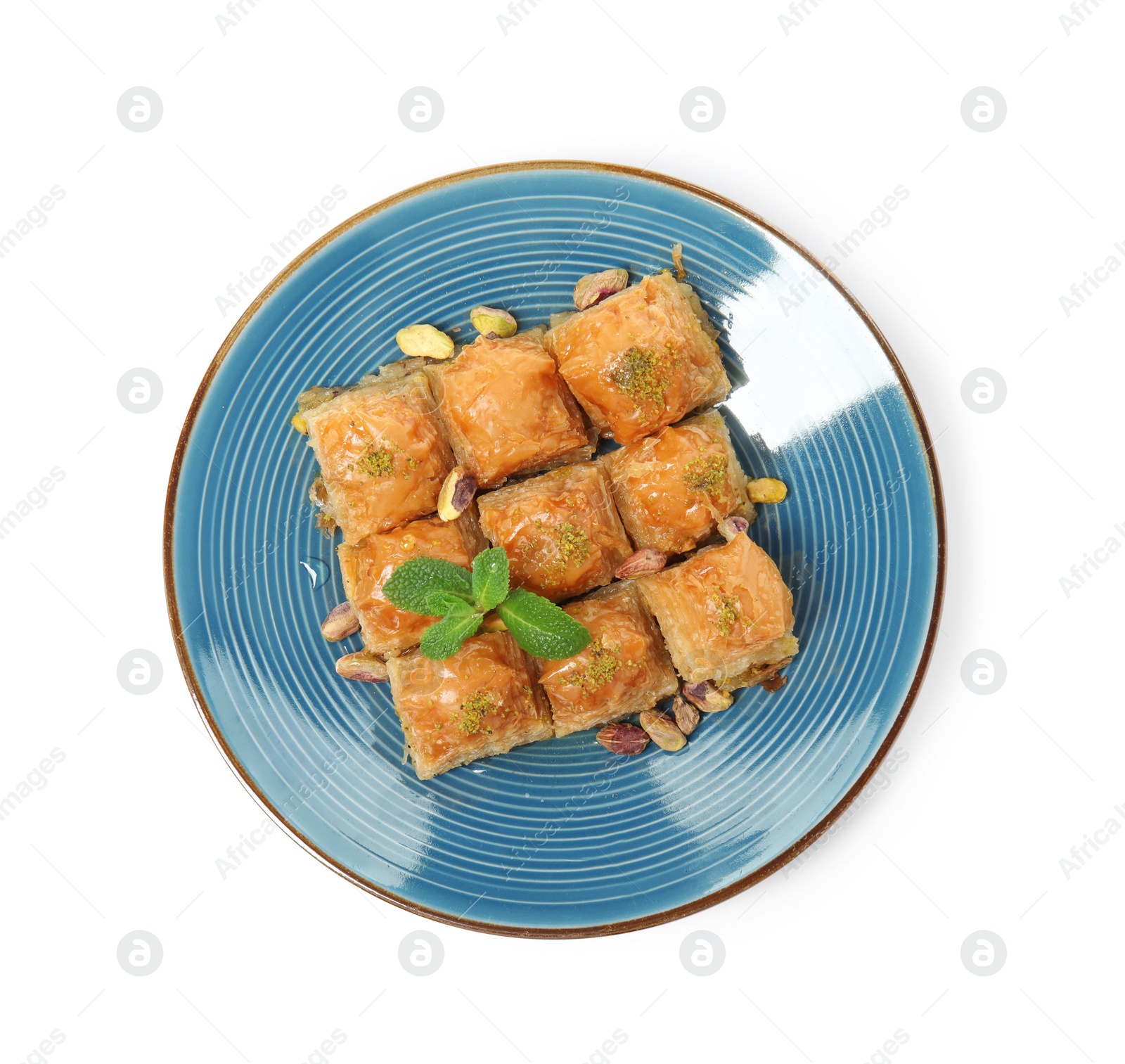 Photo of Plate of delicious baklava with pistachio nuts on white background, top view