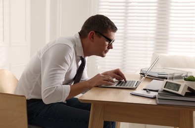 Photo of Man with bad posture working on laptop in office