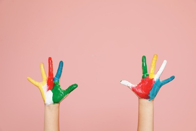 Photo of Little child's painted hands on color background