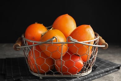Photo of Delicious fresh persimmons on grey table, closeup