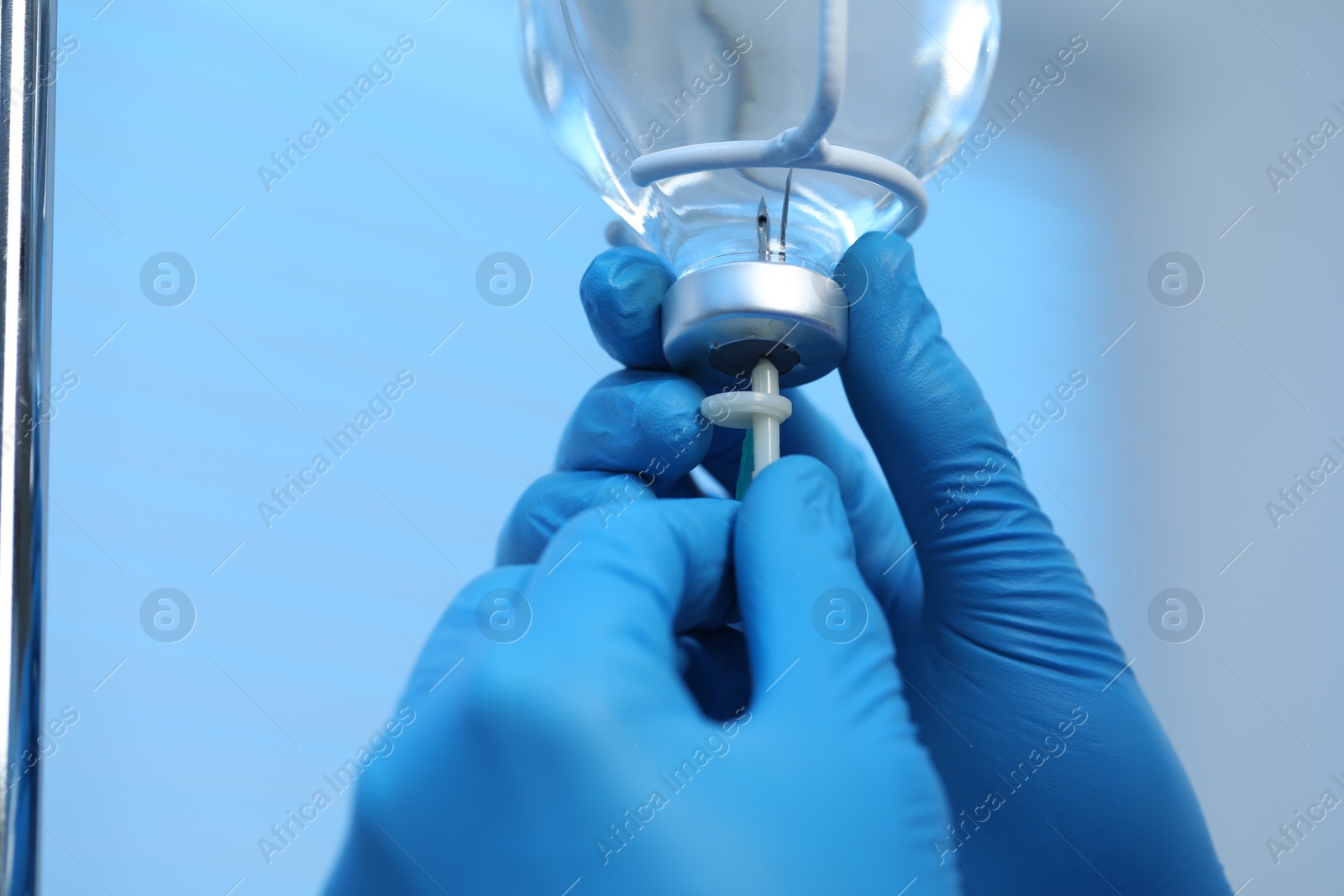 Photo of Nurse setting up IV drip in hospital, closeup