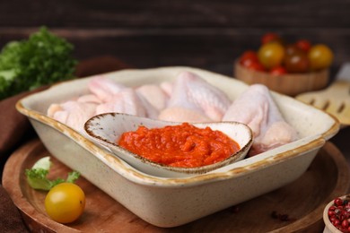 Fresh marinade and raw chicken on table, closeup