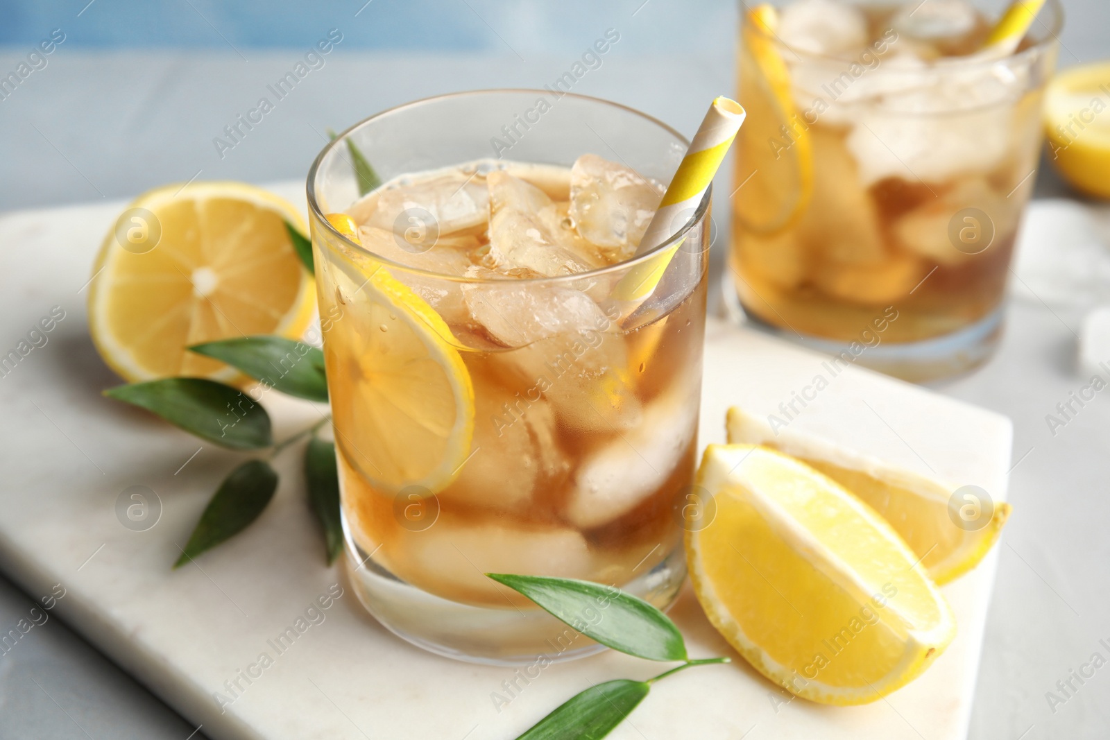 Photo of Glass of lemonade with ice cubes and fruit on table