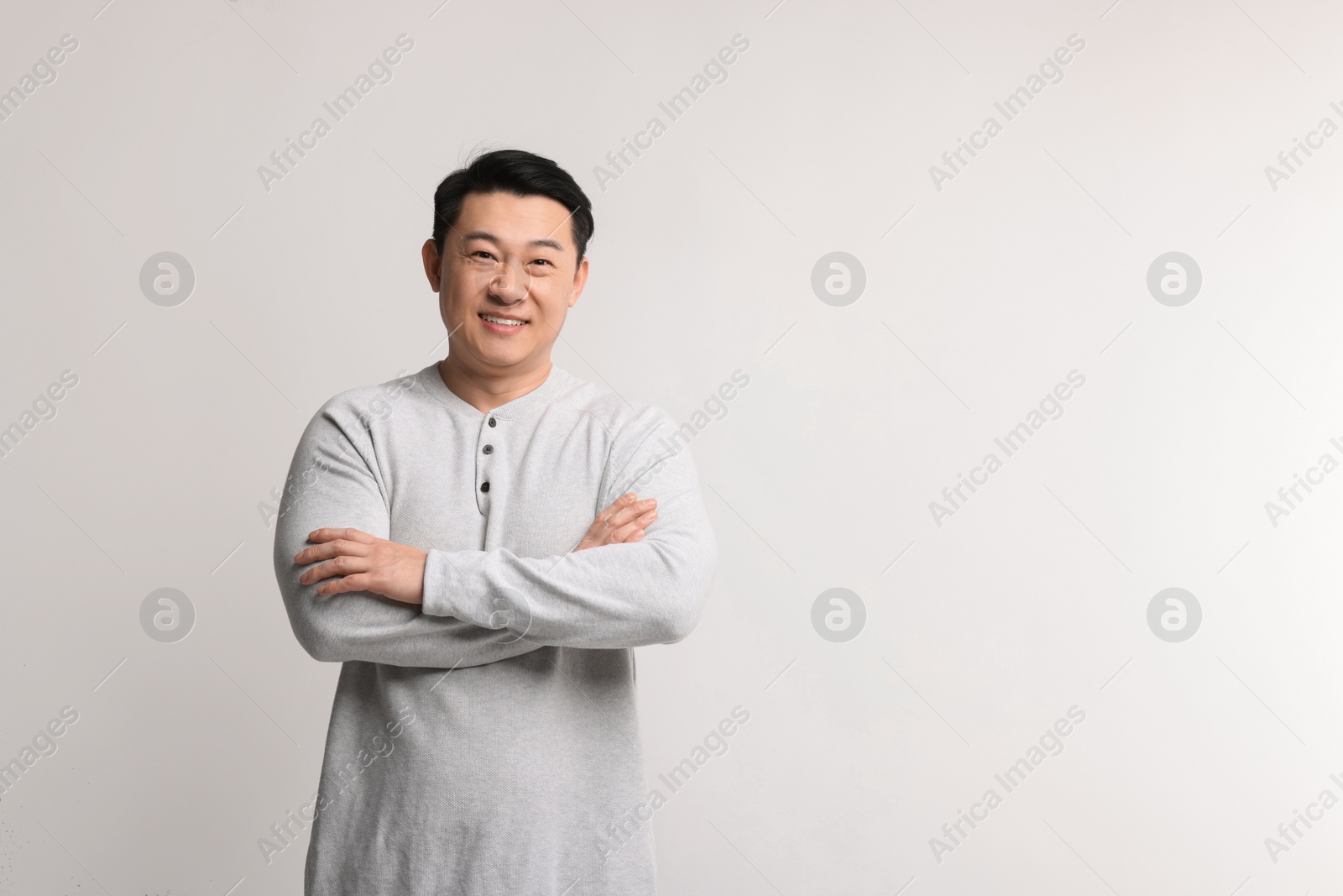 Photo of Portrait of happy man on light background. Space for text