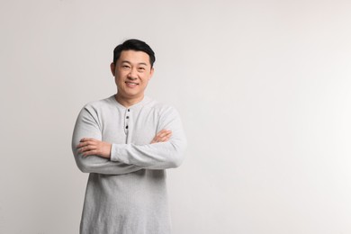 Portrait of happy man on light background. Space for text