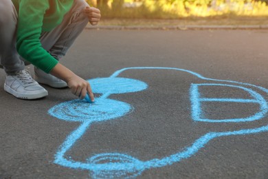 Photo of Child drawing car with chalk on asphalt, closeup