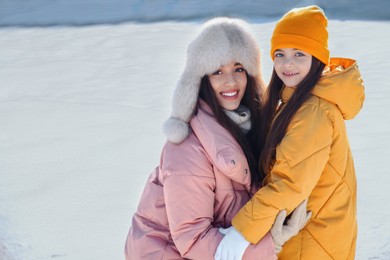 Mother and daughter spending time together at outdoor ice skating rink