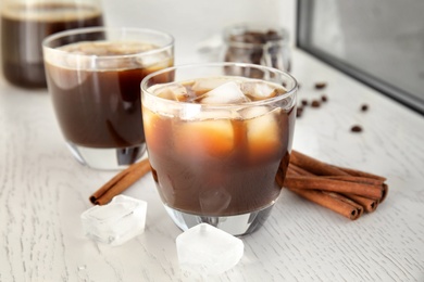 Glasses of coffee drink with ice cubes on table