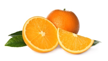 Photo of Cut and whole fresh ripe oranges with green leaves on white background