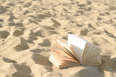 Open book on sandy beach. Space for text