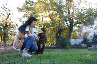 Photo of Woman with her German Shorthaired Pointer dog in park, space for text
