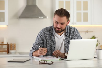 Young man working with laptop at home