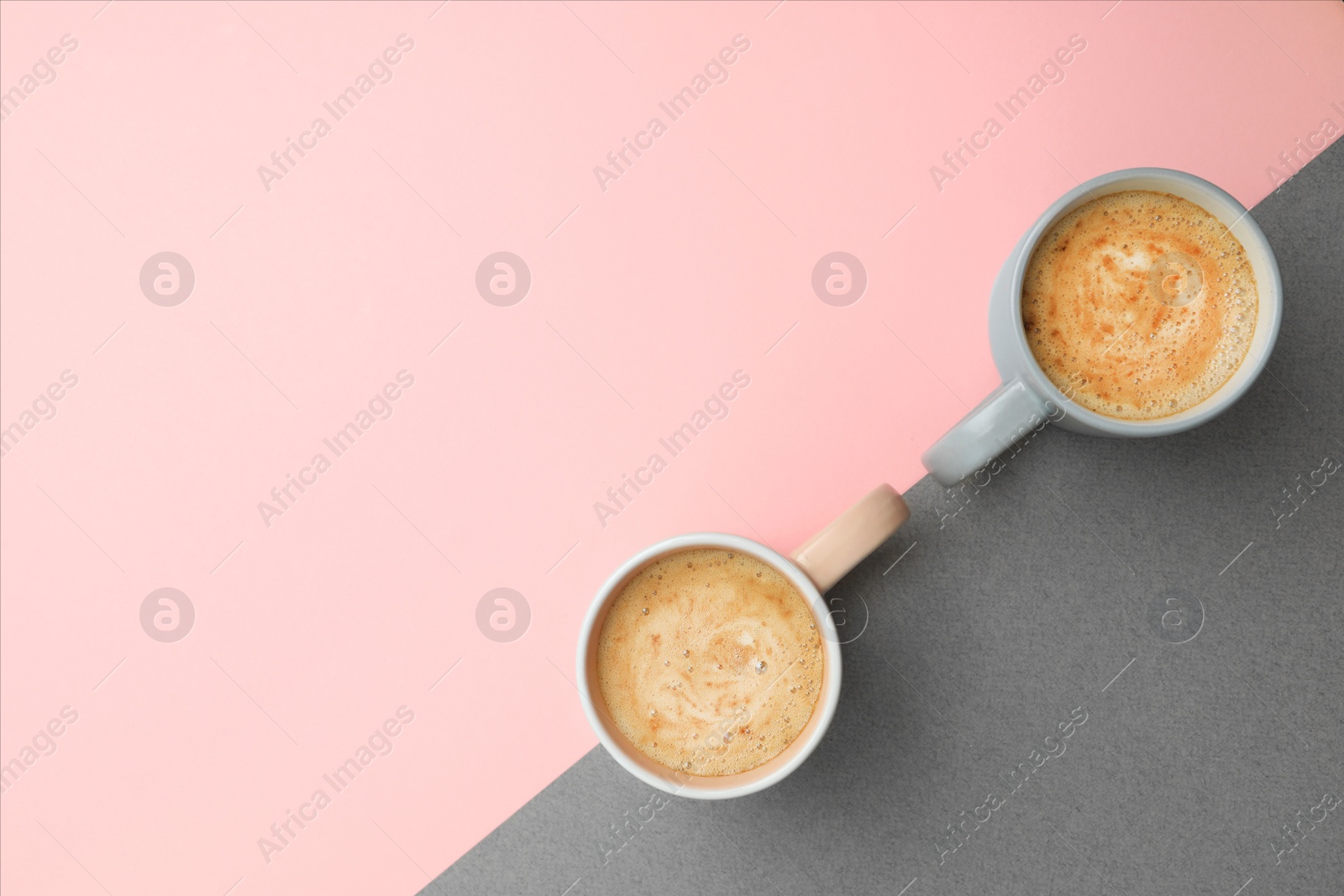 Photo of Cups of coffee on color background, top view. Space for text