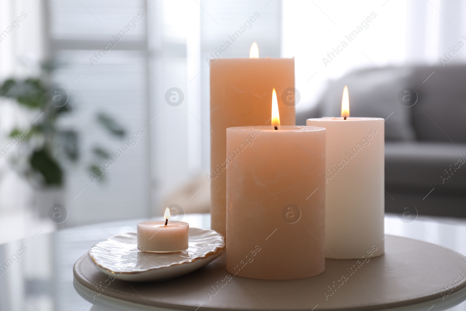 Photo of Burning candles on table indoors. Interior elements