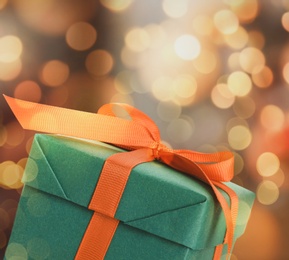 Image of Christmas gift box on blurred background, bokeh effect