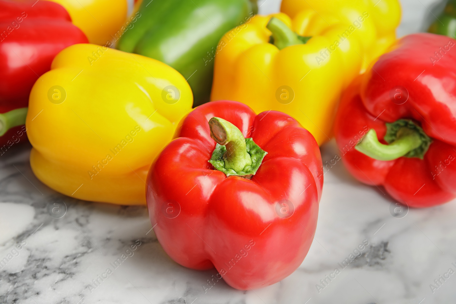 Photo of Raw ripe paprika peppers on marble background