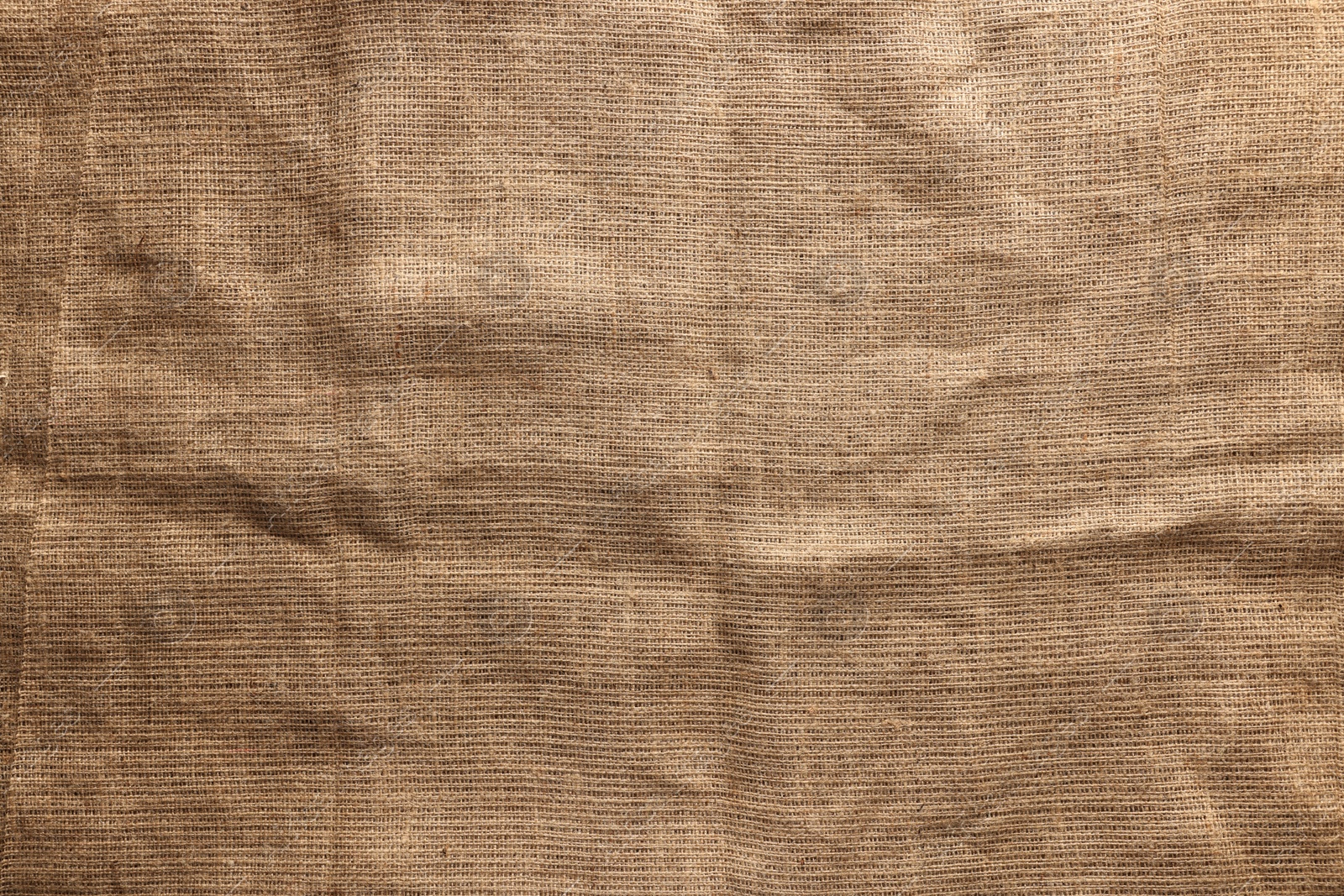 Photo of Texture of natural burlap fabric as background, top view