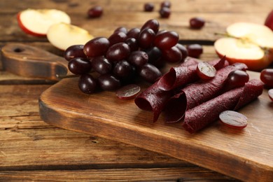 Composition with delicious fruit leather rolls on wooden table