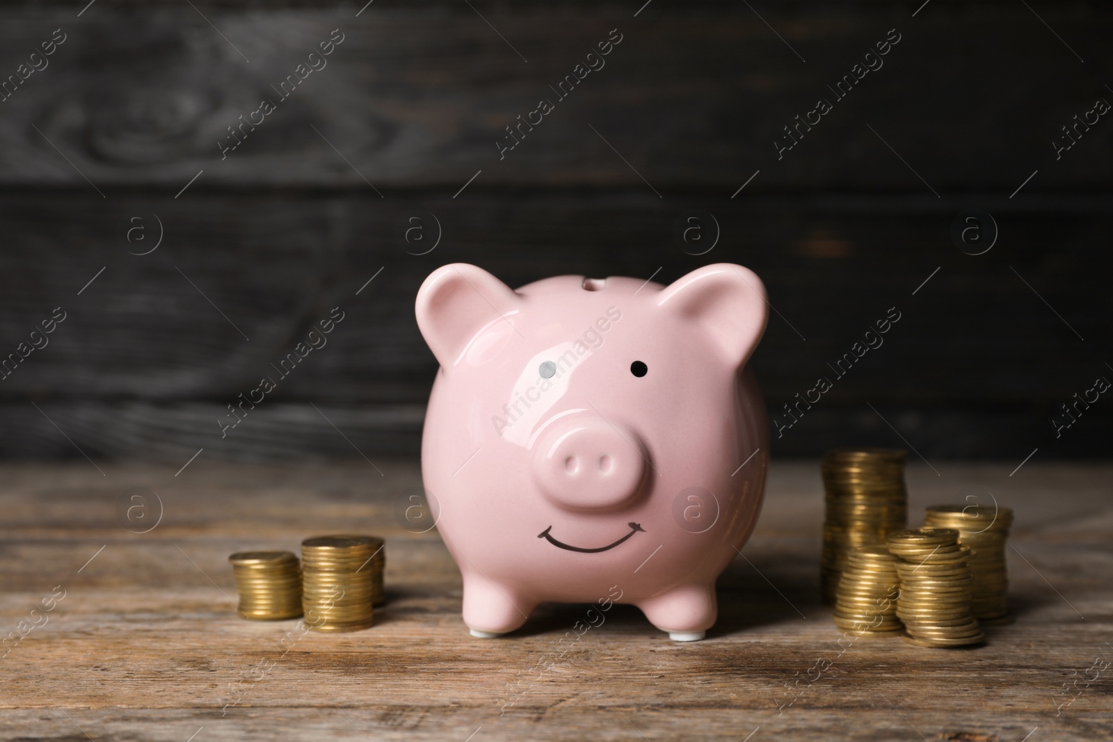 Photo of Piggy bank with coins on wooden table
