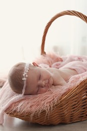 Photo of Adorable little baby sleeping in wicker basket at home