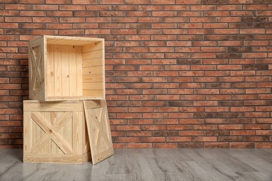 Photo of Wooden crates on floor at brick wall. Space for text