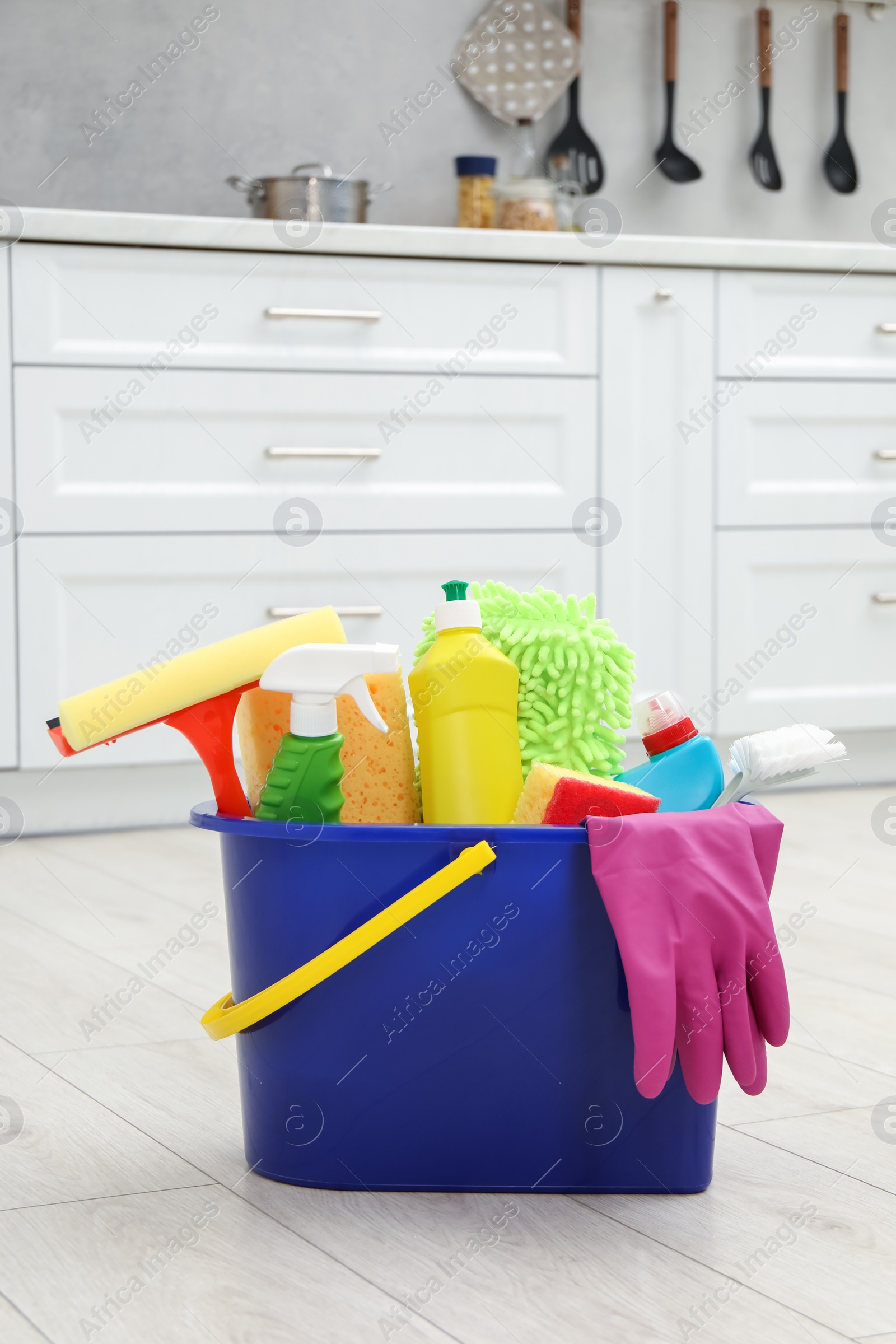 Photo of Different cleaning supplies in bucket on floor