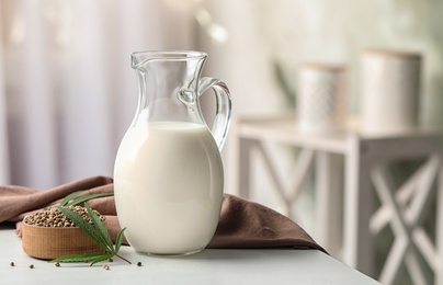 Photo of Composition with hemp milk on white table indoors