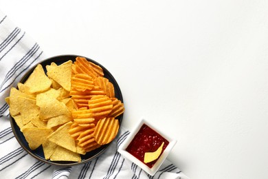 Photo of Tasty tortilla and ridged chips with ketchup on white table, flat lay. Space for text