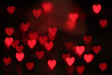 Photo of Blurred view of red heart shaped lights on black background