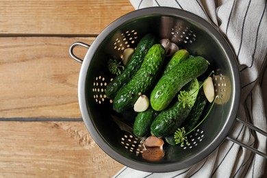 Photo of Fresh cucumbers and other ingredients prepared for canning on wooden table, top view. Space for text