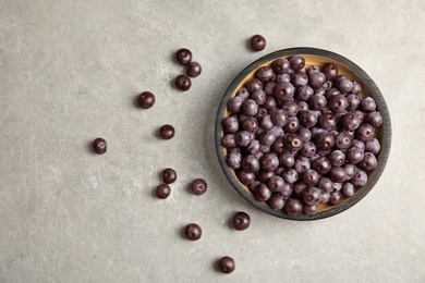 Plate with fresh acai berries on table, top view