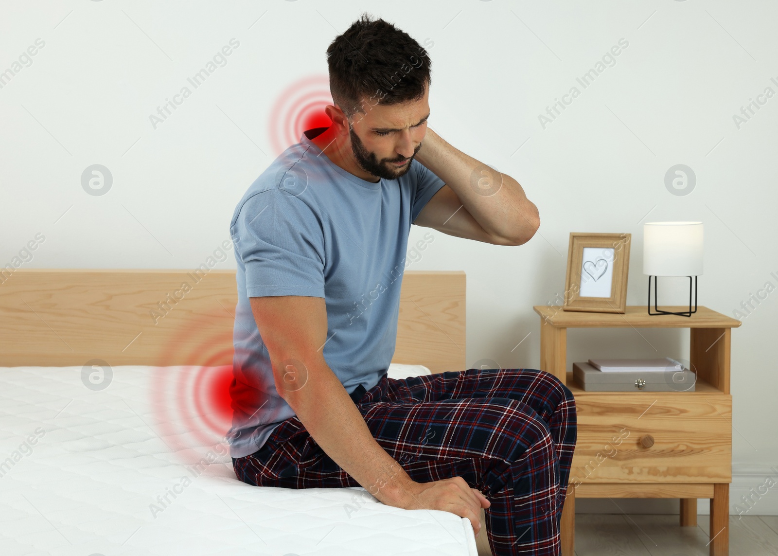 Image of Man suffering from neck pain after sleeping on uncomfortable mattress at home