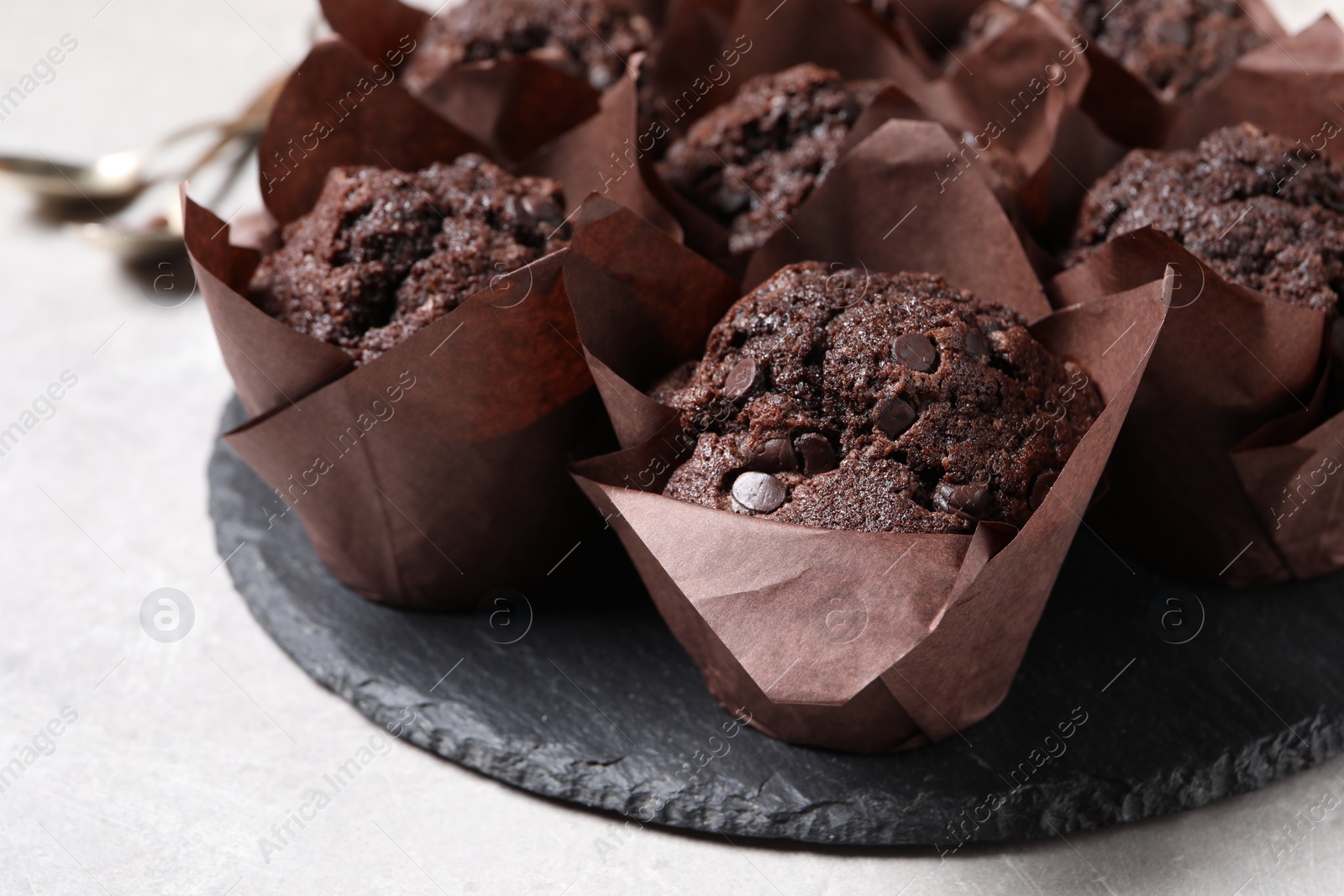 Photo of Tasty chocolate muffins on light table, closeup