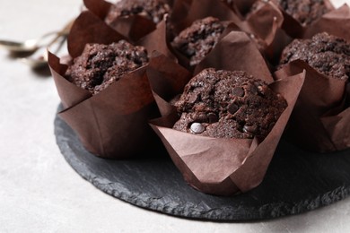 Tasty chocolate muffins on light table, closeup