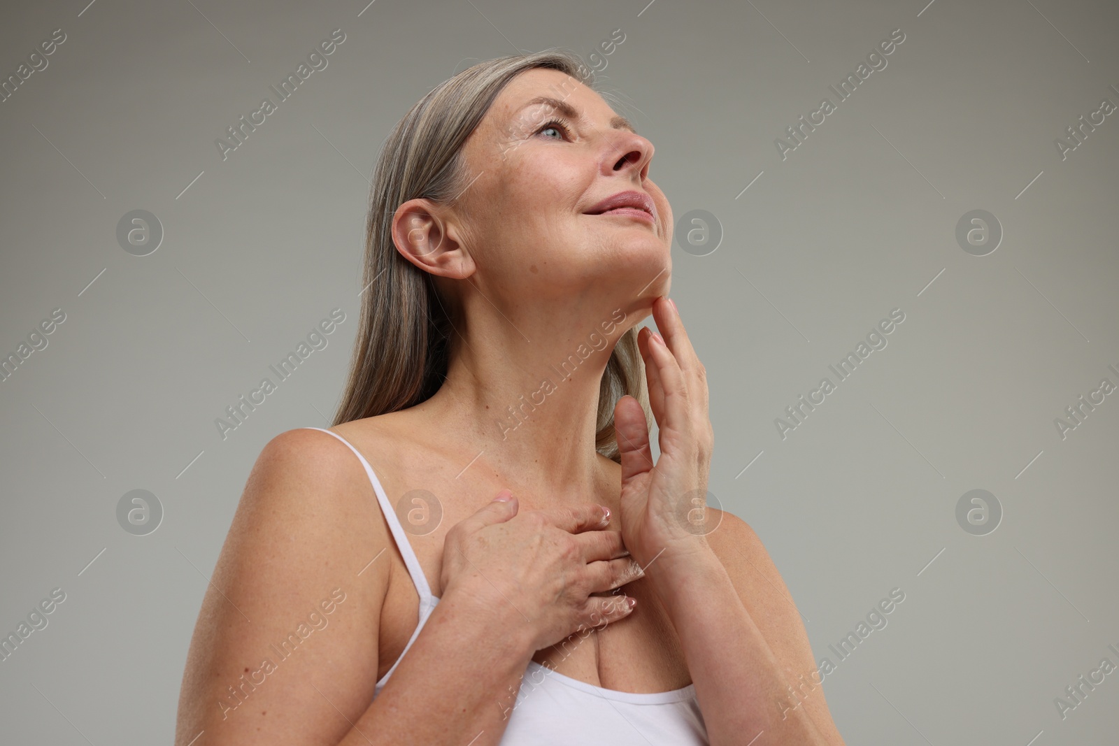 Photo of Beautiful woman with healthy skin on grey background, low angle view