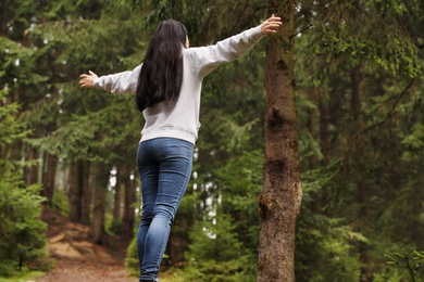 Photo of Woman on walk in beautiful coniferous forest