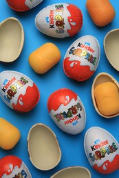 Sveti Vlas, Bulgaria - June 29, 2023: Kinder Surprise Eggs and plastic capsules on light blue background, flat lay