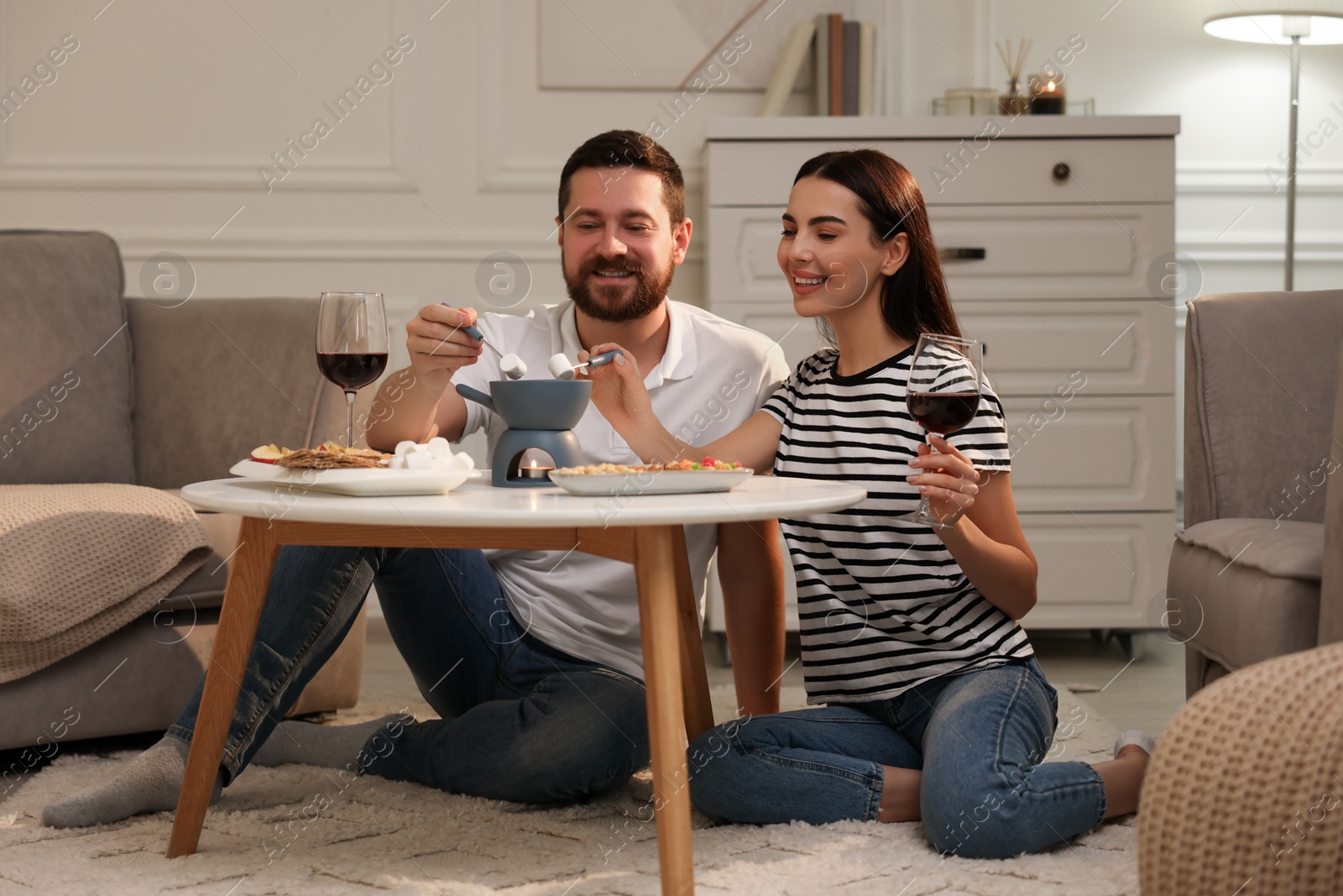 Photo of Affectionate couple enjoying fondue during romantic date at home