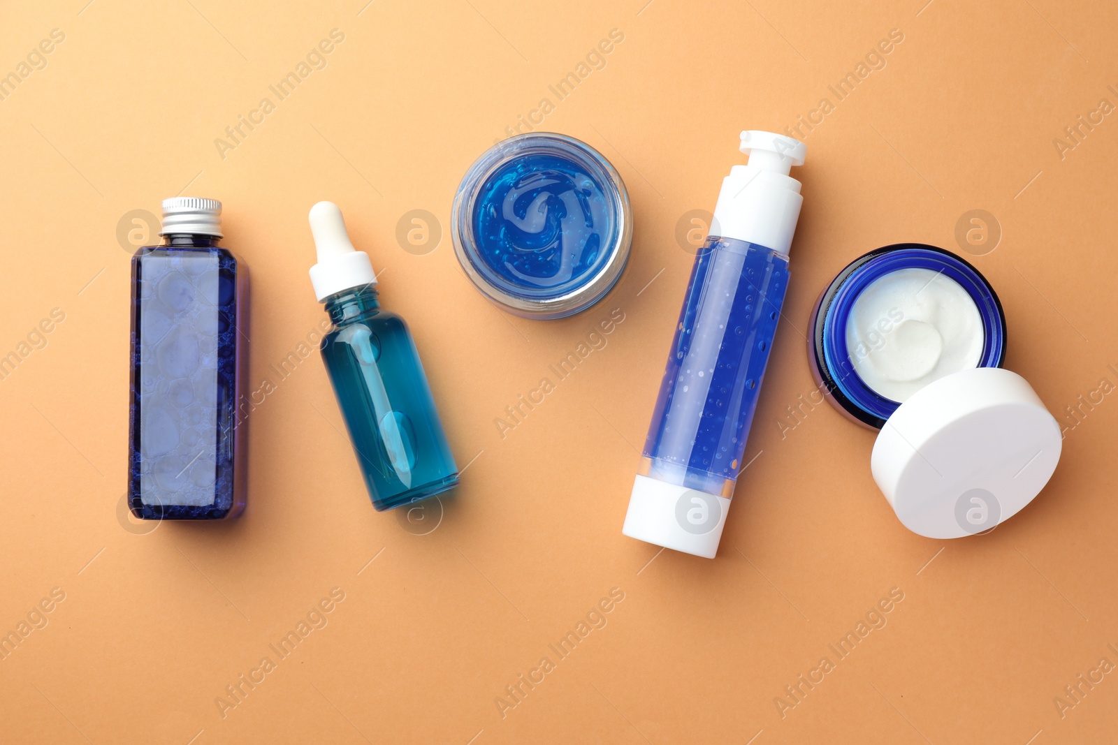 Photo of Set of cosmetic products on orange background, flat lay