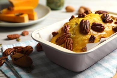 Photo of Delicious pumpkin bread with pecan nuts on light wooden table, closeup