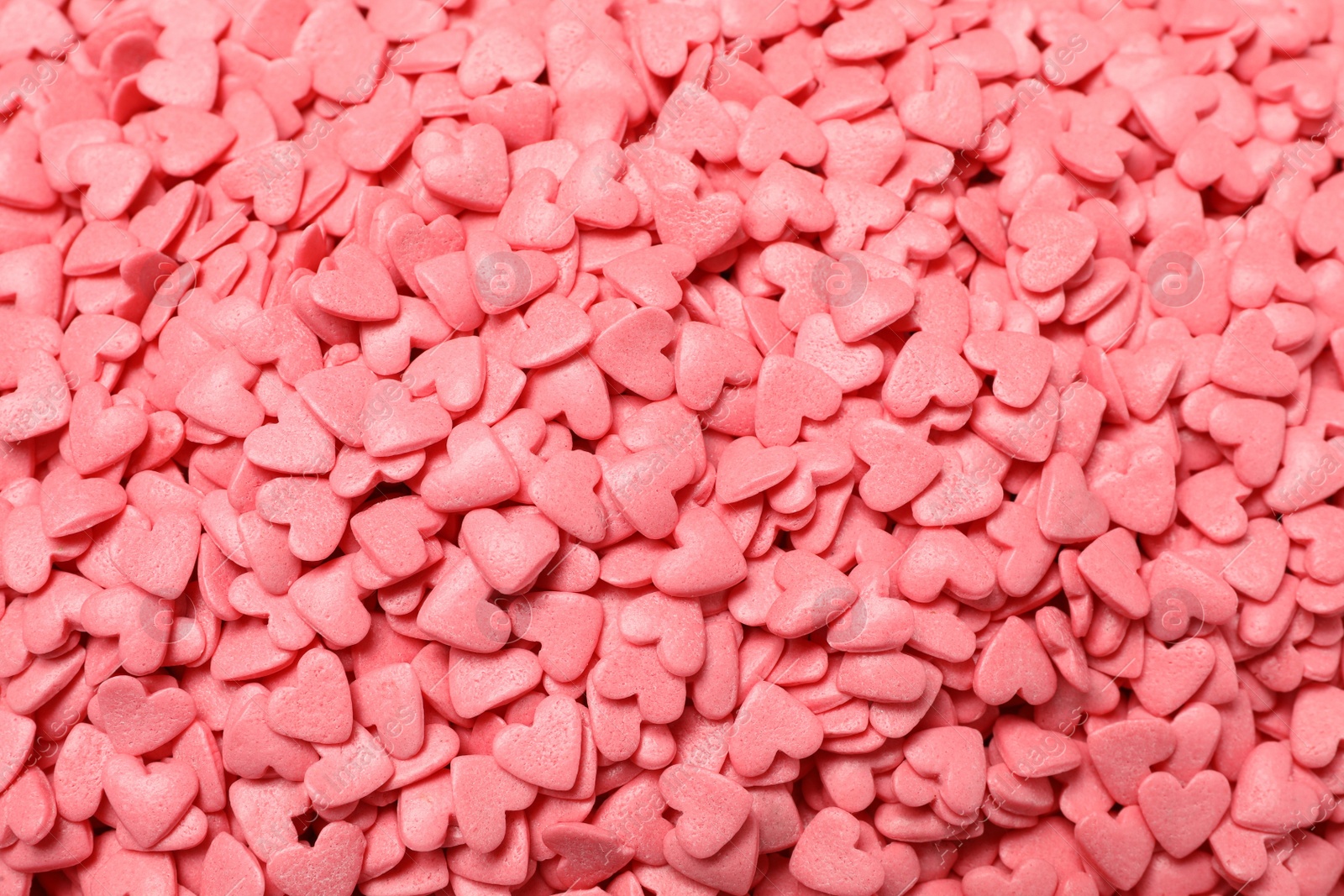 Photo of Sweet candy hearts as background, top view