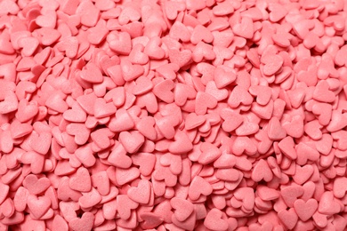 Photo of Sweet candy hearts as background, top view